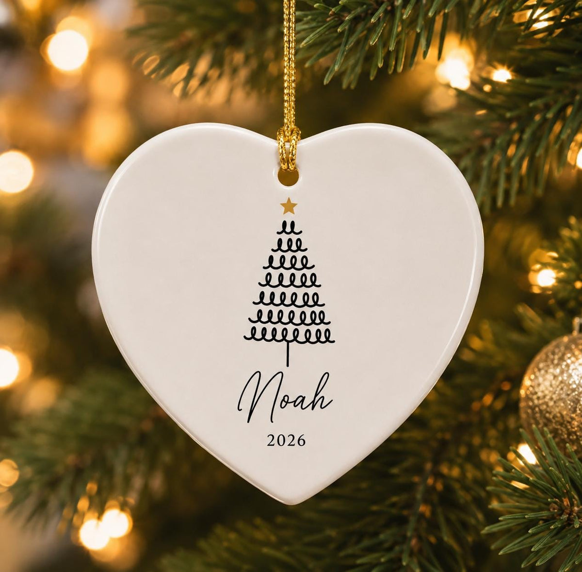 Heart ceramic ornament with a looped Christmas tree design and the name Noah 2026 on a gold string