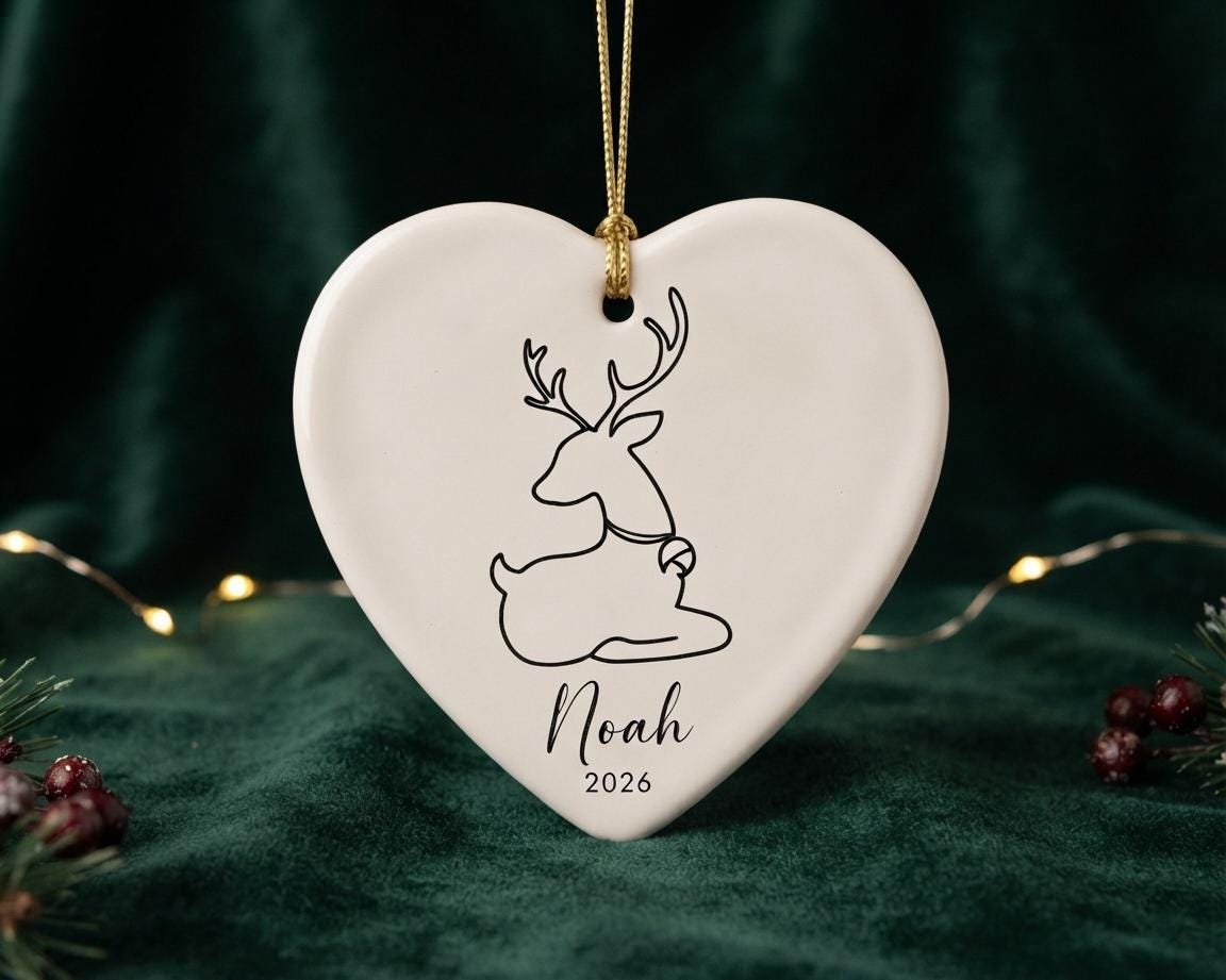 Heart ceramic ornament with a sitting reindeer design and the name Noah 2026