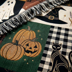 Close view of the woven witch hat, jack-o-lantern pumpkins and black cat on buffalo check