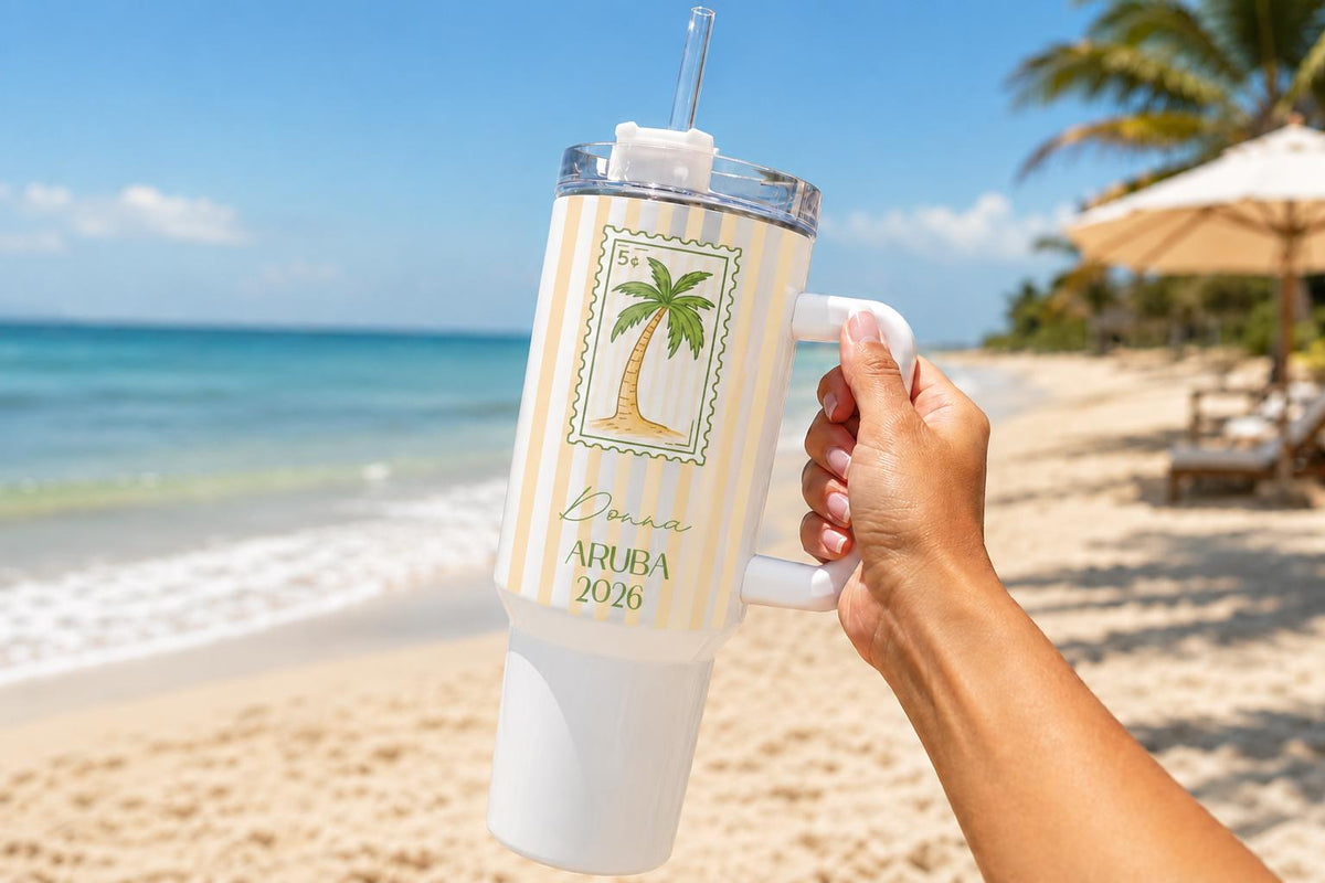 40oz handle tumbler with a palm tree stamp design held on the beach