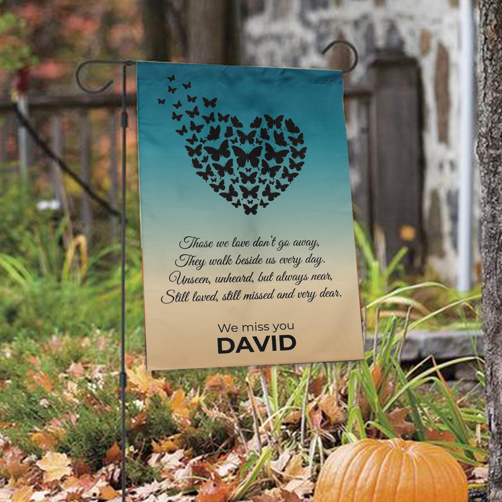 Butterfly heart Those We Love Don't Go Away memorial garden flag among autumn leaves with a pumpkin