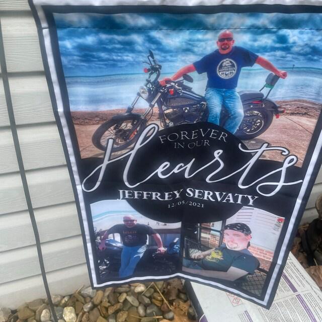 Customer photo of a Forever In Our Hearts photo memorial flag hanging outside a house