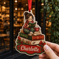 Hand holding personalized cozy reading girl on books wooden ornament outside a bookshop