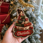 Cozy reading girl keepsake ornament with custom name held by a frosted tree