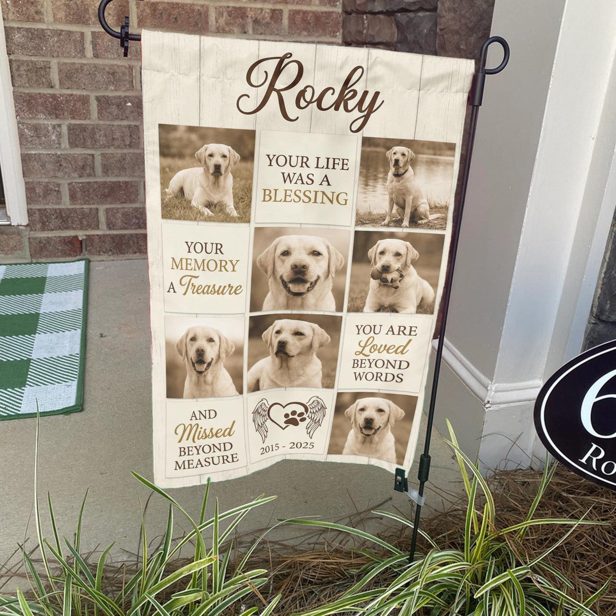 Rustic dog memorial photo collage garden flag with name and years on a stand by a brick front porch