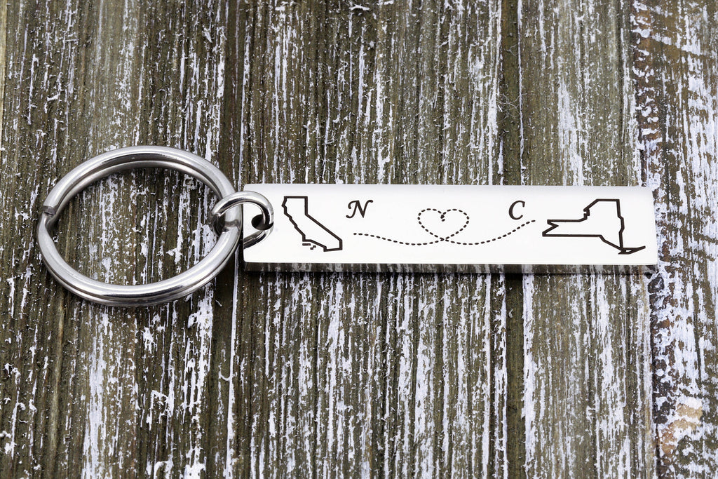 Engraved stainless steel keychain with two state outlines, a dotted heart path and initials