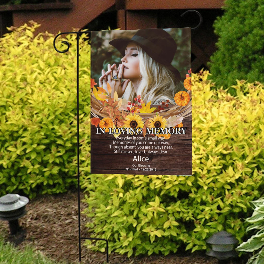 Fall memorial photo garden flag with sunflowers, poem and name in front of bright yellow shrubs