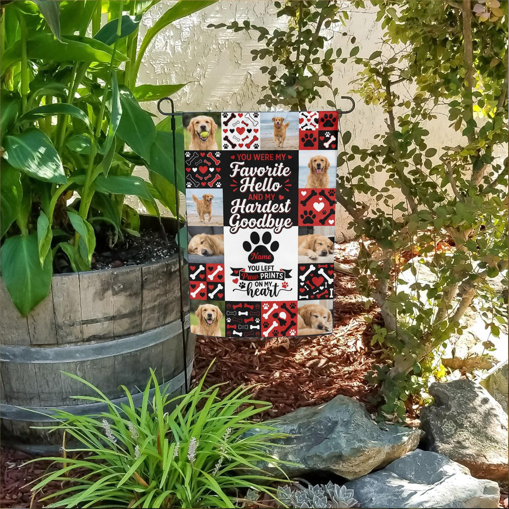 Favorite Hello Hardest Goodbye dog memorial photo collage garden flag in a flower bed beside a wooden barrel planter