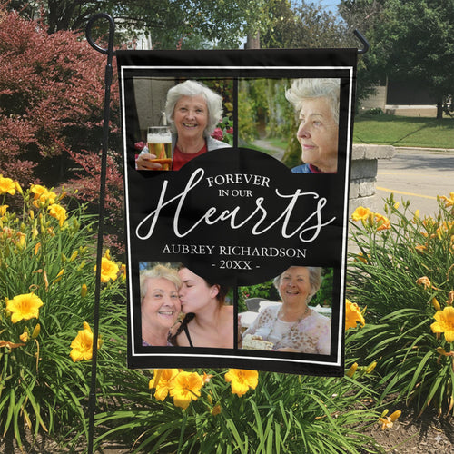 Forever In Our Hearts four photo memorial garden flag with name and year in a garden bed with yellow lilies