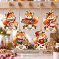 Five personalized fox Christmas wooden ornaments with names and year hanging in a kitchen