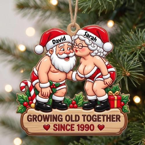 Cheeky Santa couple kiss ornament named David and Sarah on a snowy tree