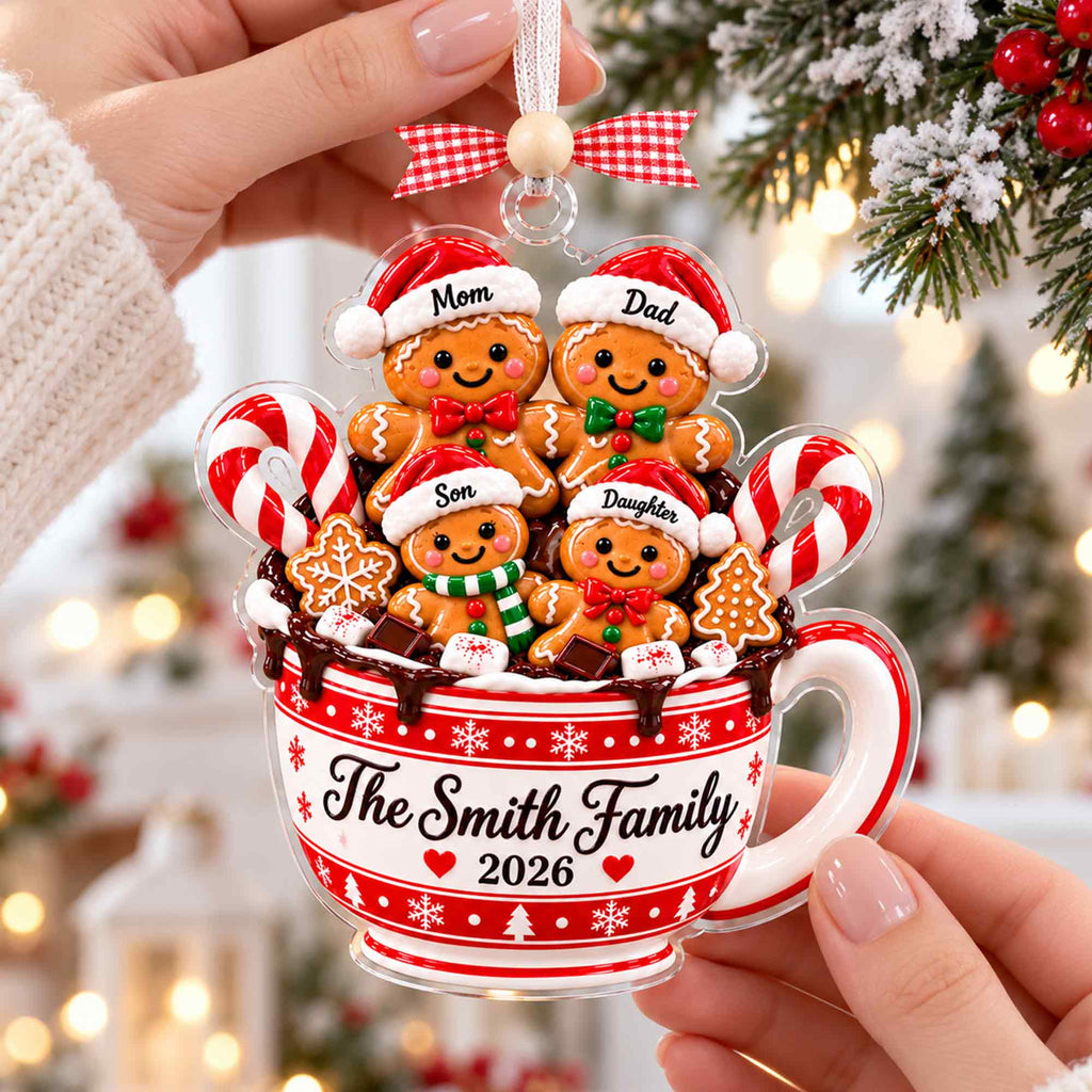 Hand holding a personalized gingerbread family mug ornament
