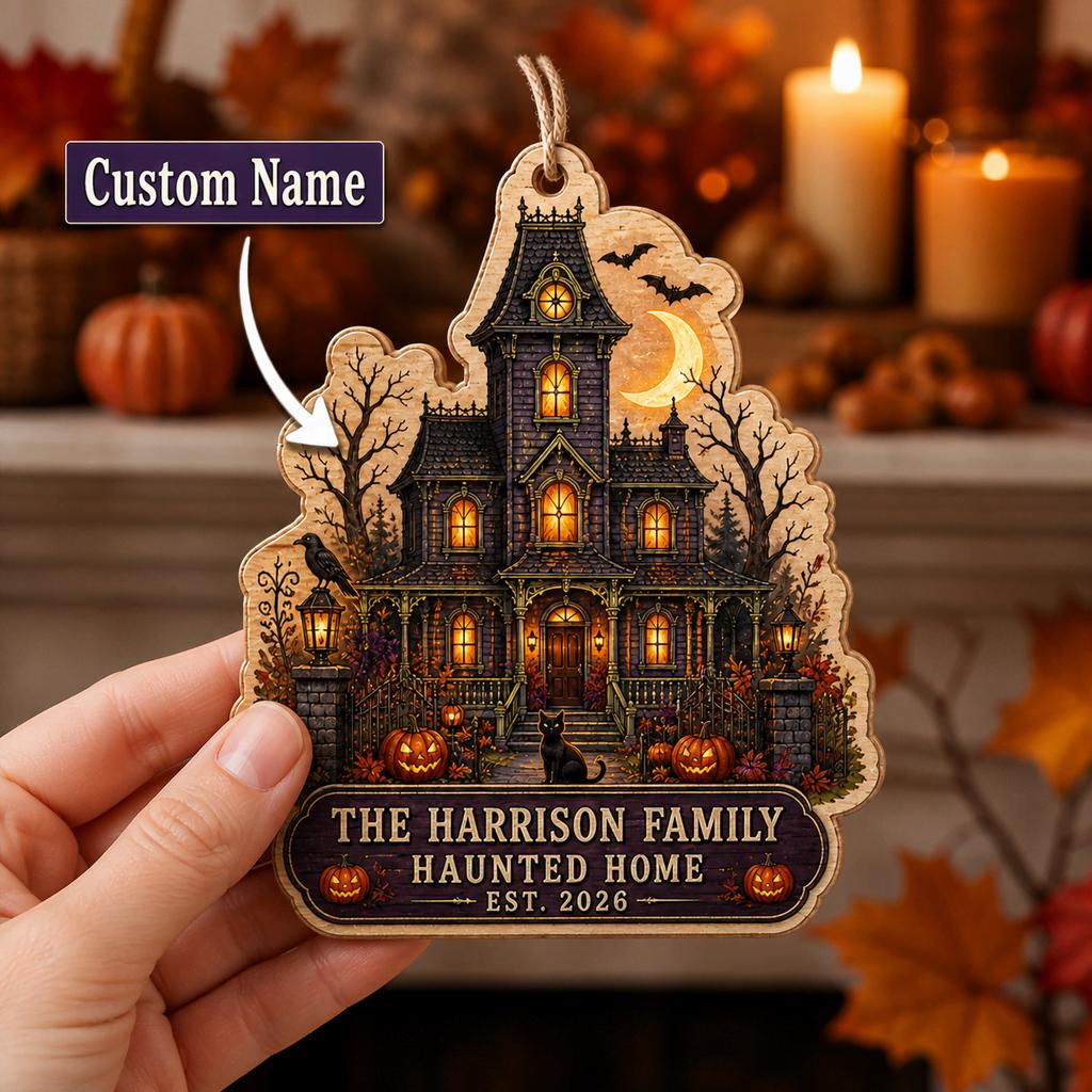 Hand holding a personalized haunted house wooden ornament with family name and custom name callout