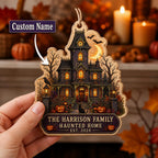 Hand holding a personalized haunted house wooden ornament with family name and custom name callout