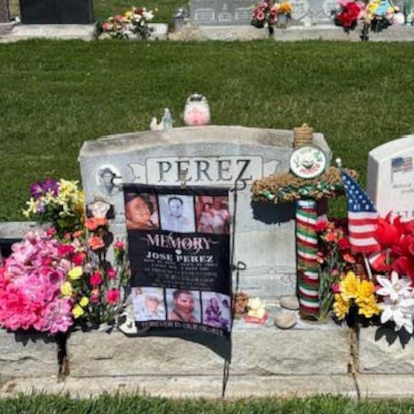 Customer photo of an In Loving Memory photo collage flag at a headstone with flowers