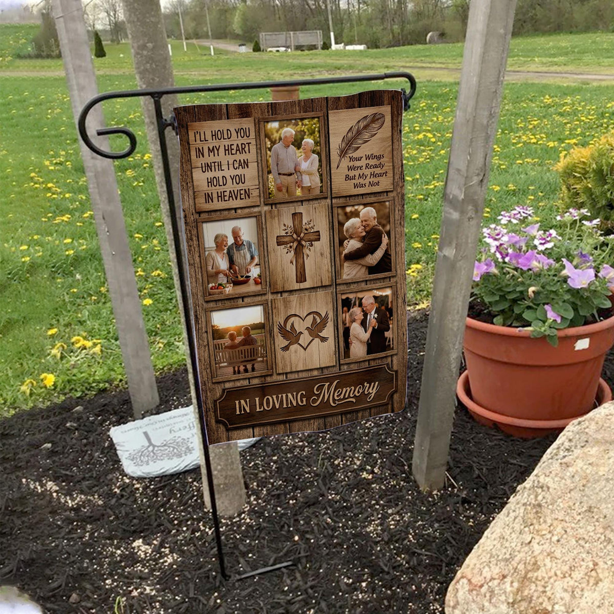 Rustic wood I Will Hold You In My Heart photo collage memorial garden flag on a garden flag stand in a yard with potted flowers