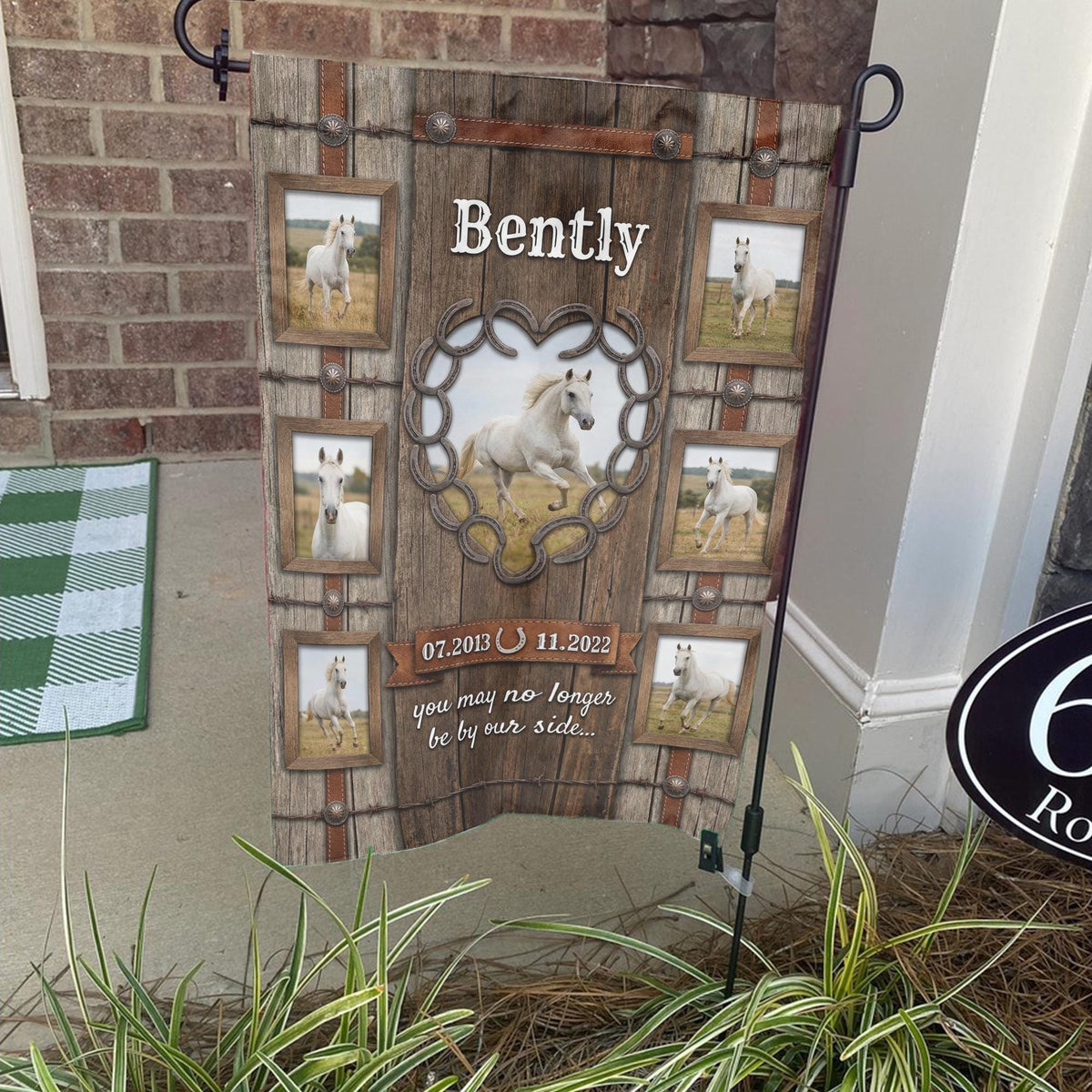 Rustic horse memorial photo collage garden flag with name on a stand by a brick front porch