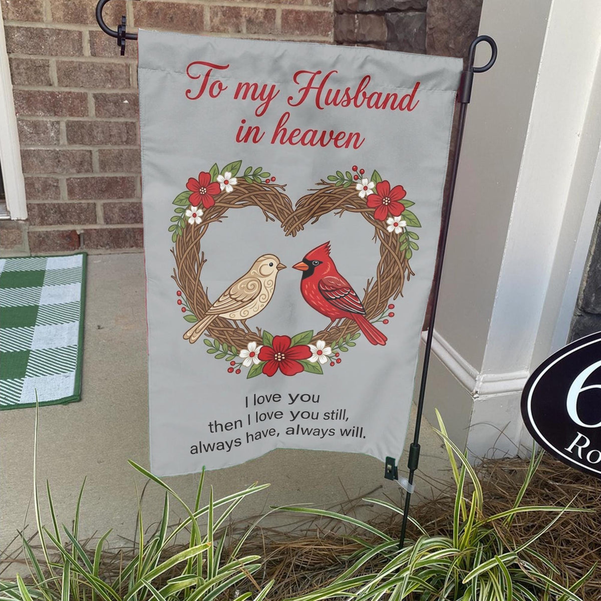 To My Husband In Heaven cardinal heart wreath memorial garden flag on a stand by a brick front porch