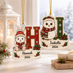 Bunny H and owl I kids initial name ornaments by a snowy window