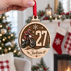 Hand holding a round motocross dirt bike wooden ornament with race number and name