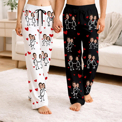 Couple wearing white and black photo pajama pants with stick figure faces and hearts