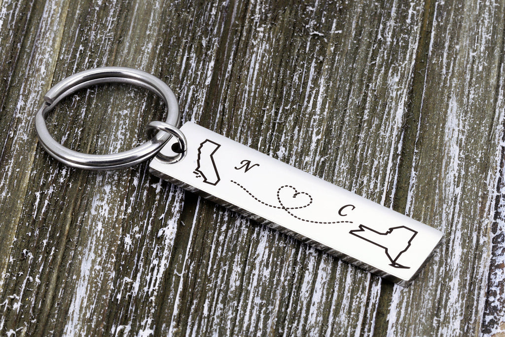 Polished stainless steel state map keychain on rustic wood