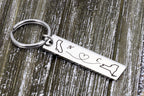Polished stainless steel state map keychain on rustic wood