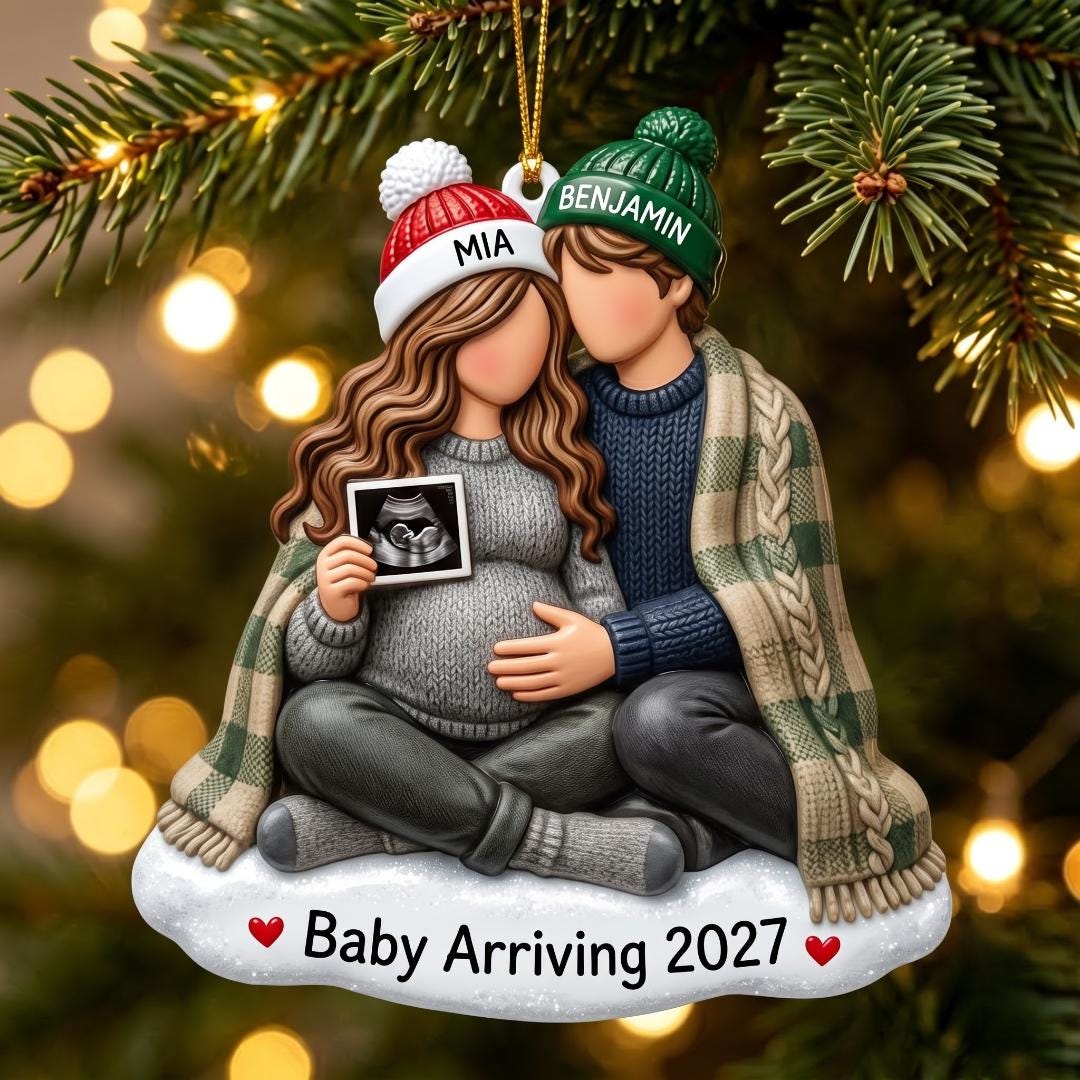 Personalized pregnancy announcement ornament with a cozy expecting couple and Baby Arriving 2027 on a Christmas tree