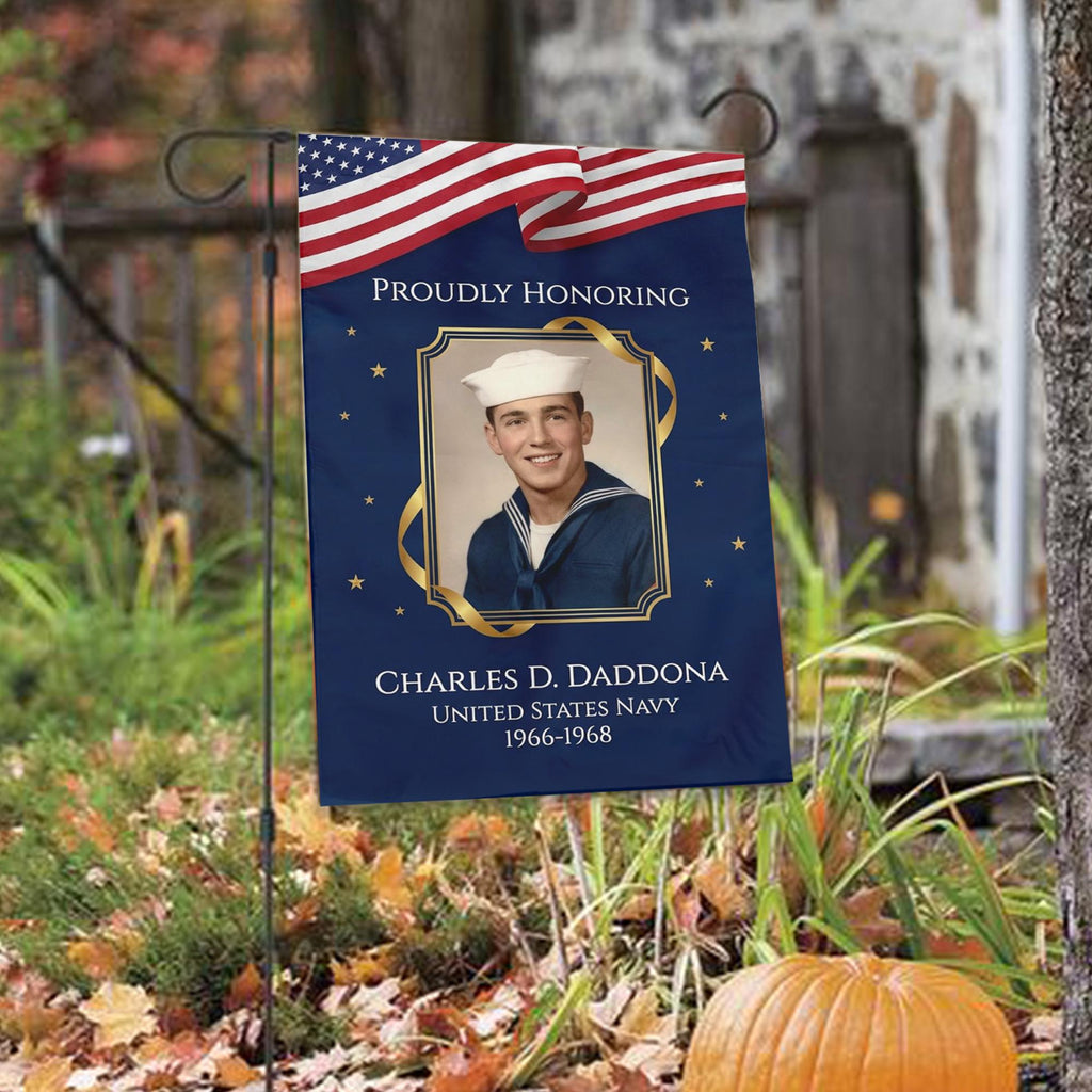 Proudly Honoring military veteran photo memorial garden flag with American flag banner among autumn leaves with a pumpkin