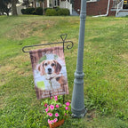Customer photo of a beagle memorial garden flag on a stand in a front lawn with pink flowers