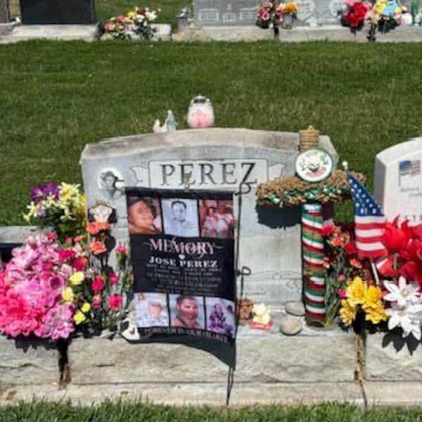 Customer photo of an In Loving Memory photo collage flag at a headstone with flowers