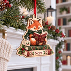 Personalized fox reading a book ornament hanging by a white fireplace mantel