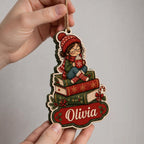 Hands holding a book stack reading girl ornament showing the layered plywood edge