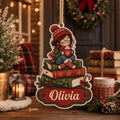 Personalized wooden ornament of a reading girl in a red beanie on stacked books