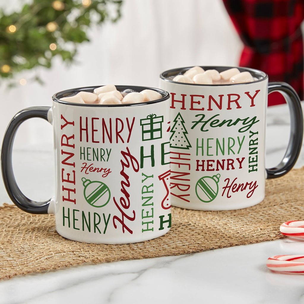 Black handle Christmas mugs printed with the name Henry repeated with holiday icons