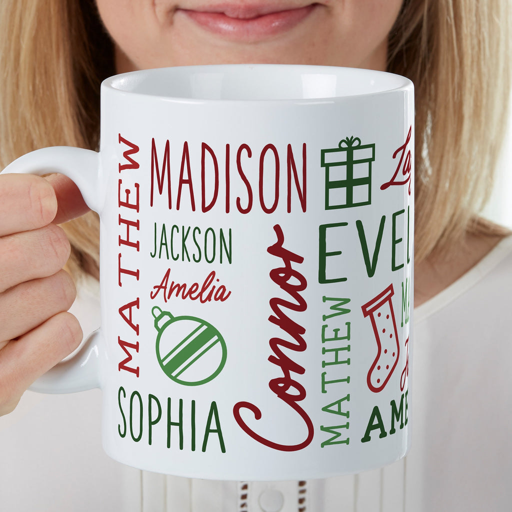 Woman holding a white Christmas mug printed with several family names and holiday icons