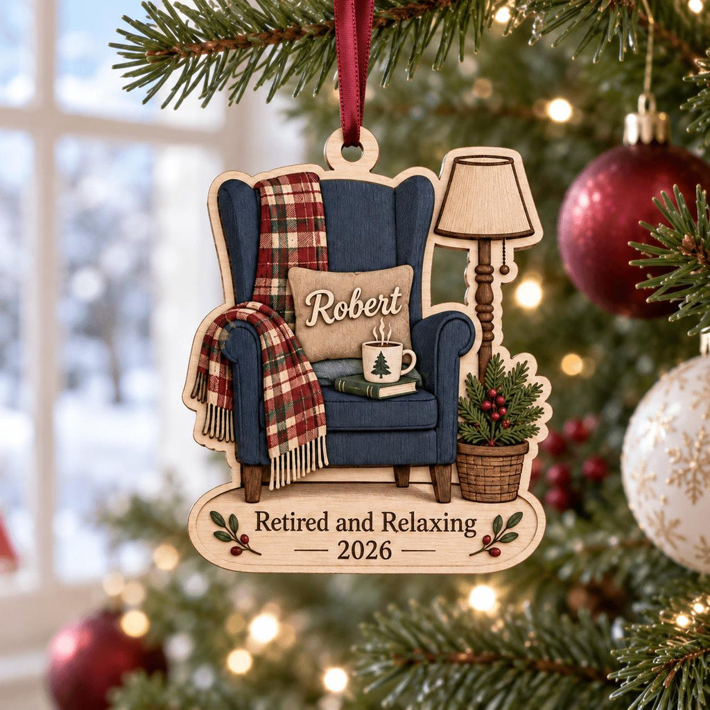 Retired and Relaxing name ornament hanging on a Christmas tree with red baubles