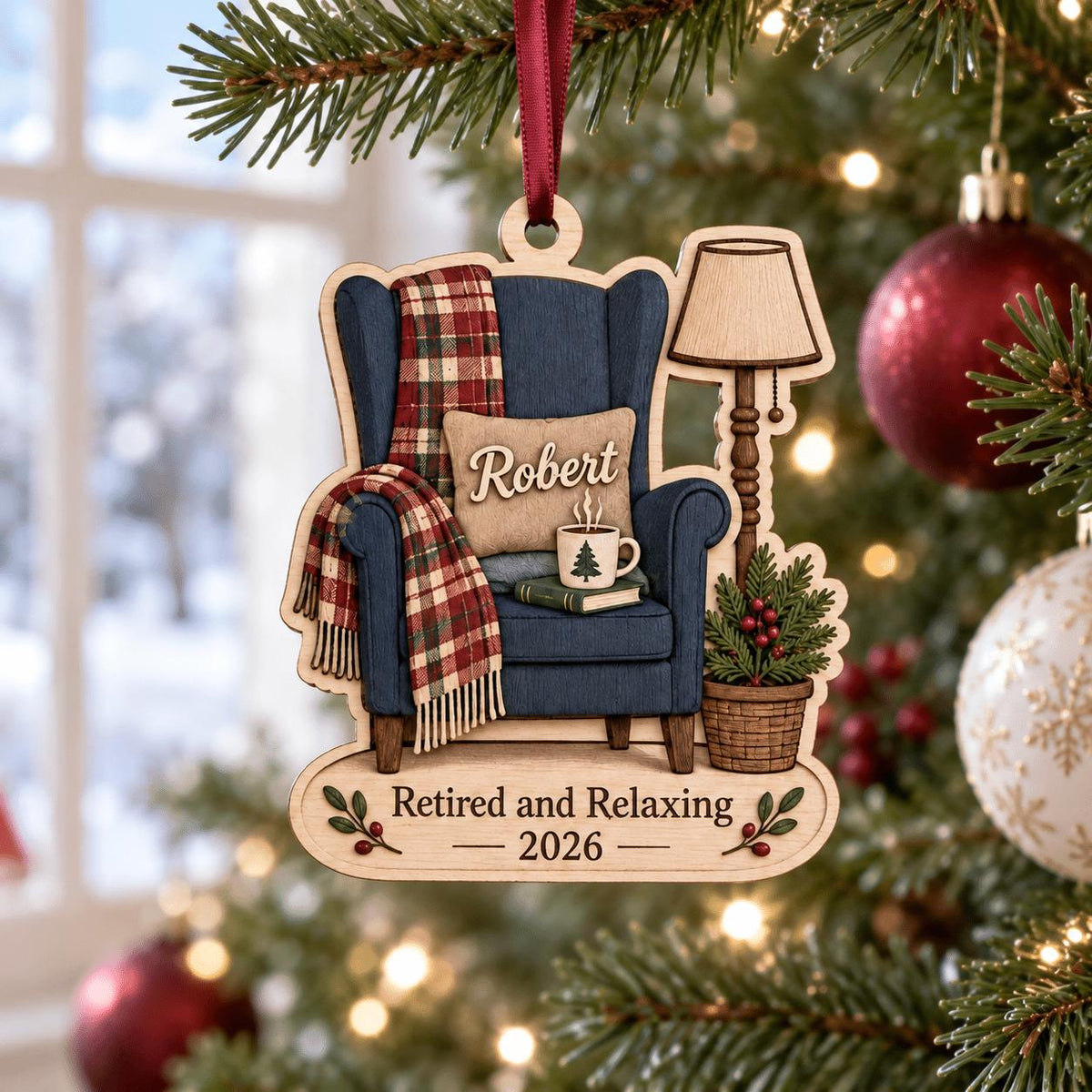 Retired and Relaxing name ornament hanging on a Christmas tree with red baubles