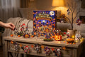 Hand opening a door on the Skeleton Halloween Party box, with skeleton pieces on the table and a twine garland