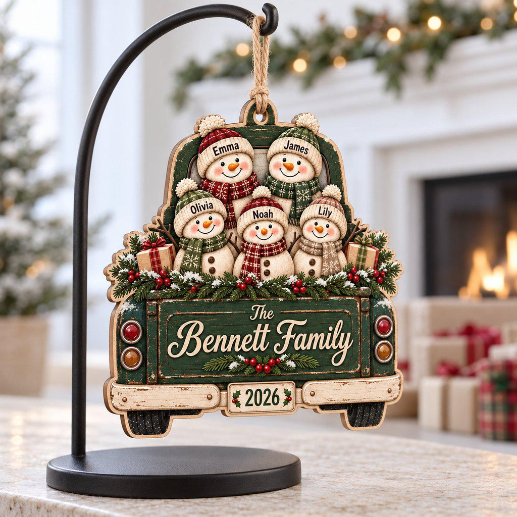 Snowman family truck wooden ornament with custom names hanging on a black display stand