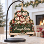 Snowman family truck wooden ornament with custom names hanging on a black display stand