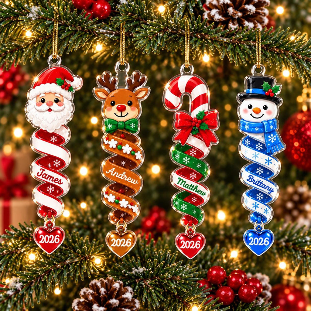 Four spiral name ornaments hanging on a lit Christmas tree