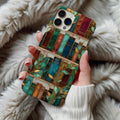 Stained glass bookshelf phone case held in hand over a cozy white faux fur throw