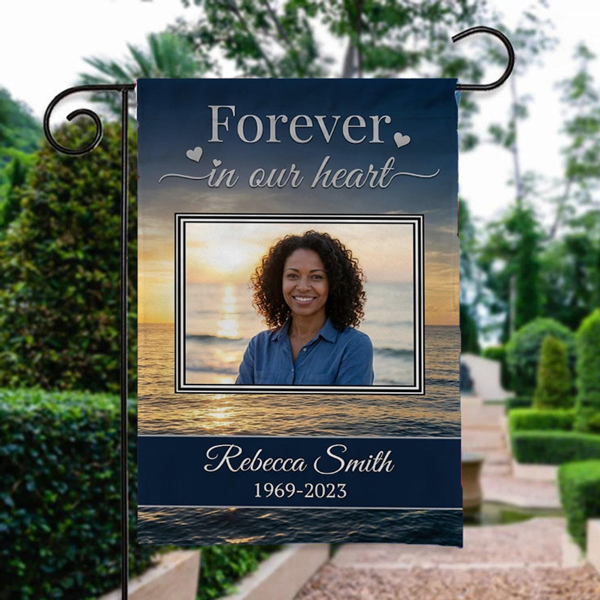 Forever In Our Heart sunset beach photo memorial garden flag with name and years beside a stone garden path