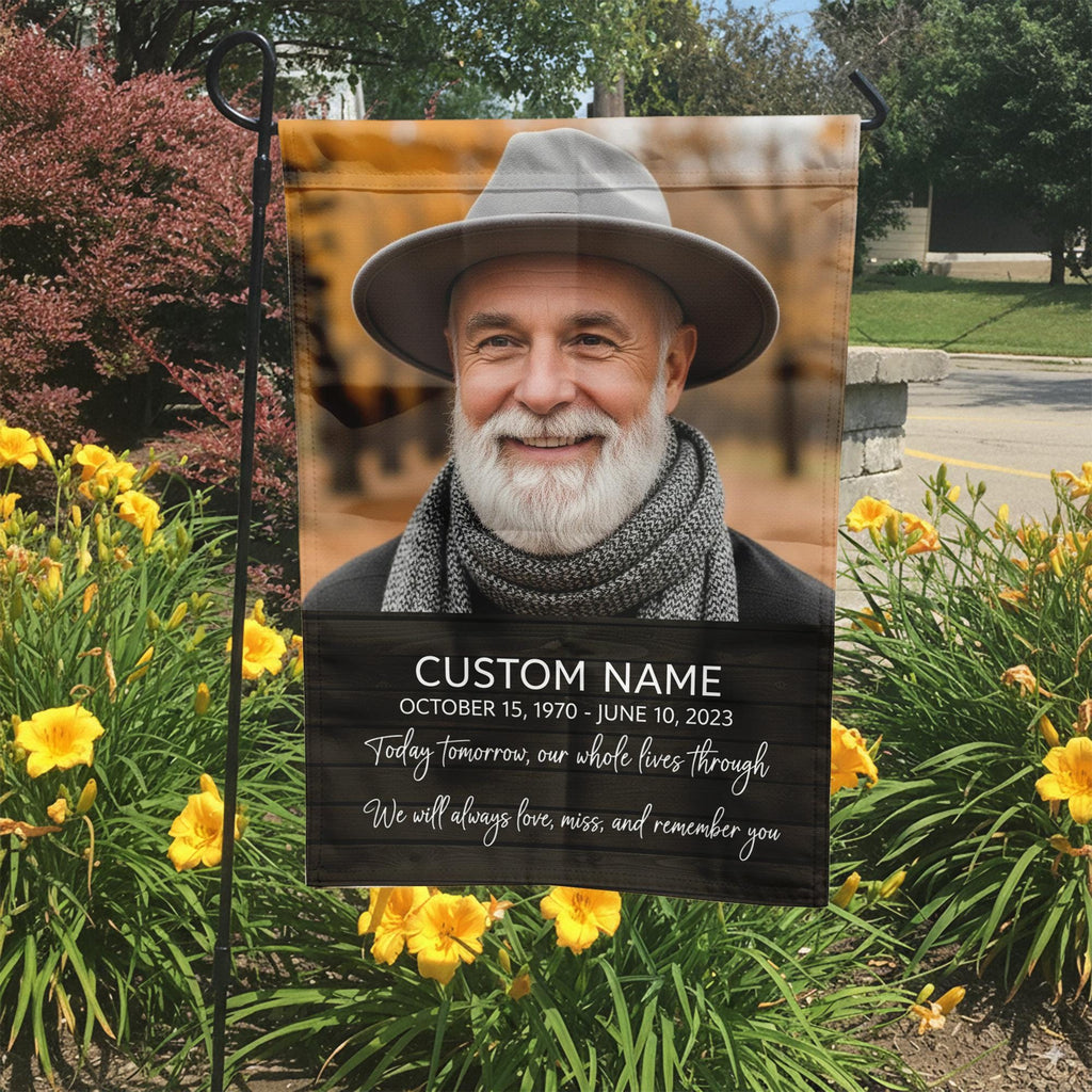 Today Tomorrow Always portrait memorial garden flag with name and dates in a garden bed with yellow lilies