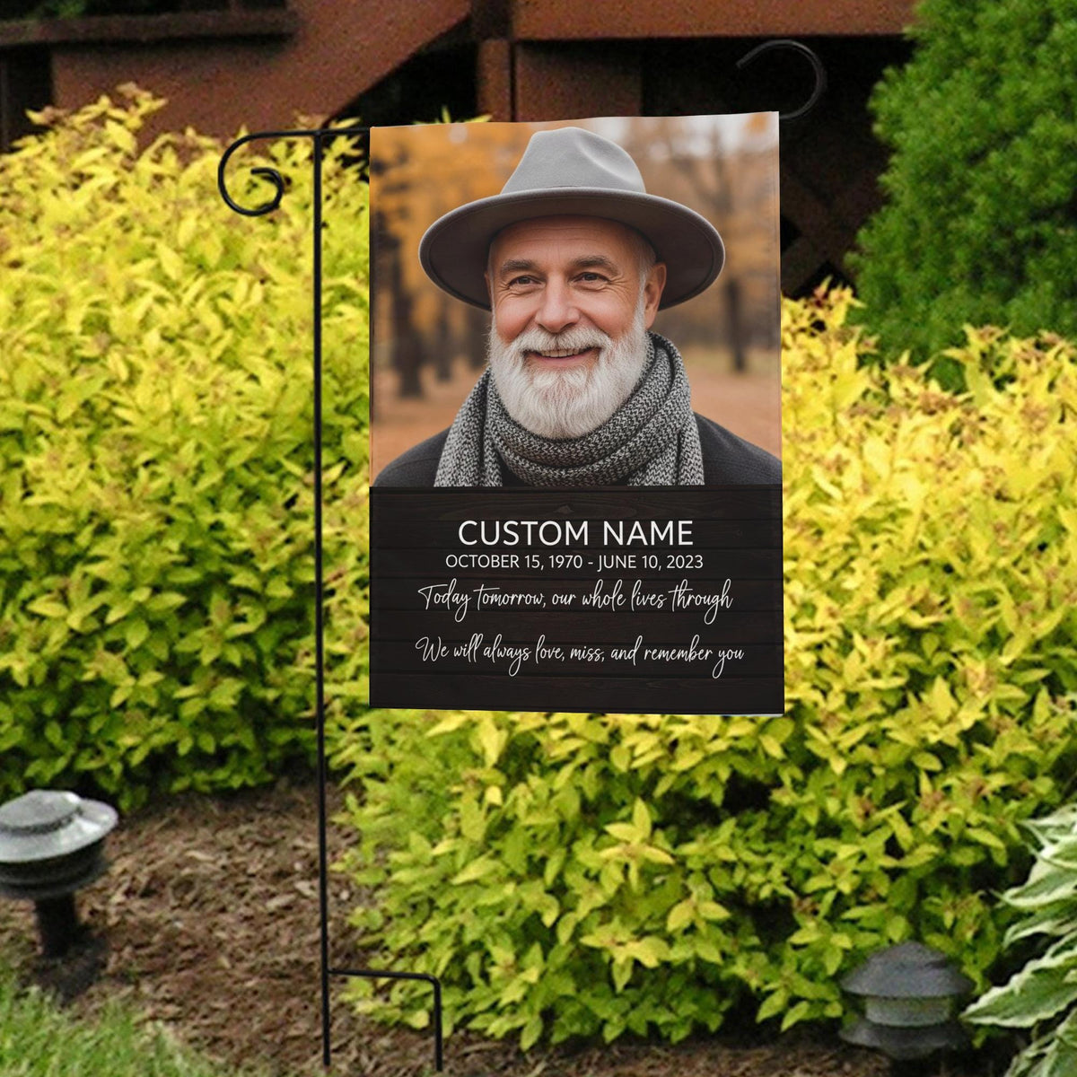 Today Tomorrow Always portrait memorial garden flag with name and dates in front of bright yellow shrubs