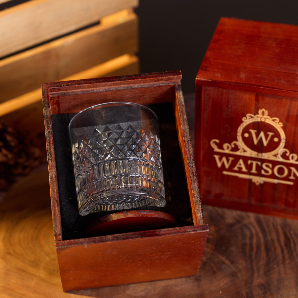 Whiskey glass resting in a wooden gift box with soft black lining