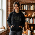 Woman wearing a black Spooky Season embroidered hoodie