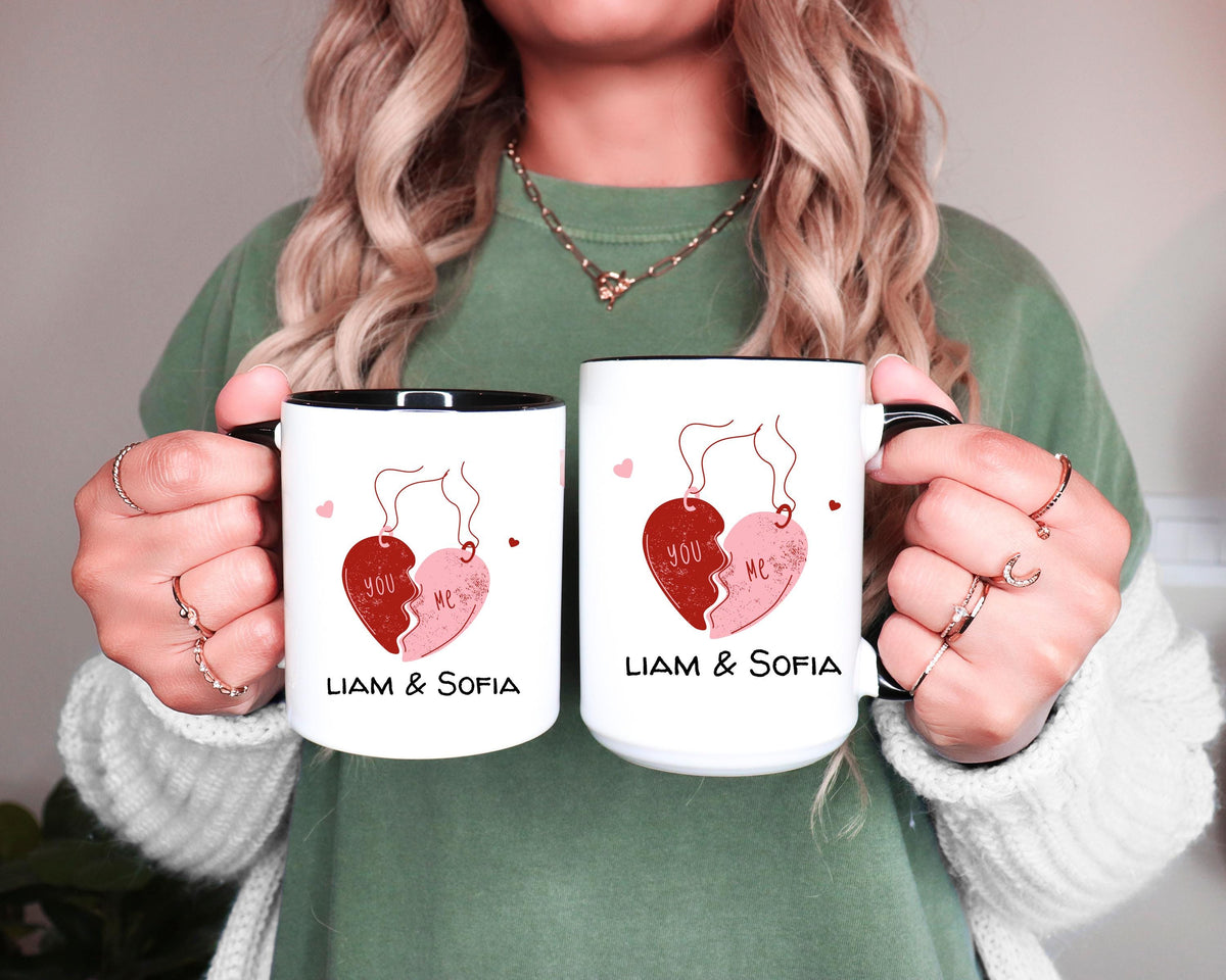Two You and Me couple mugs with names held side by side